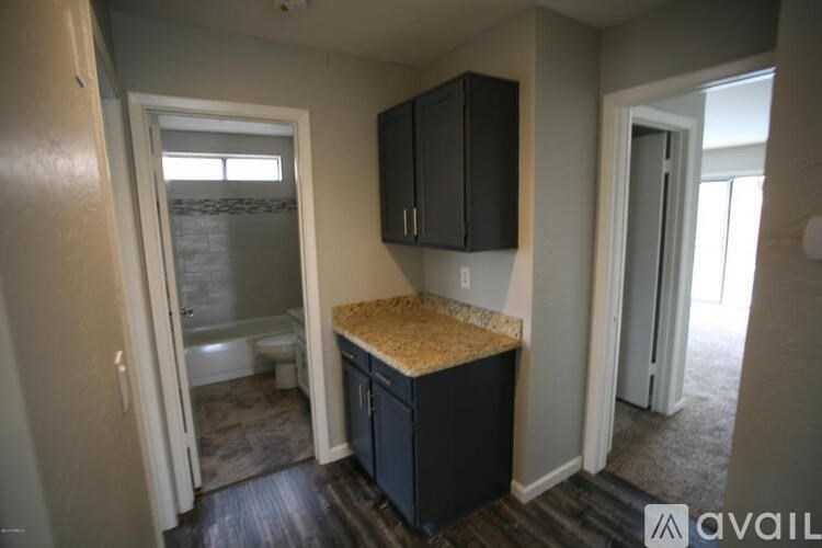 A kitchen area with a granite countertop and black cabinets.