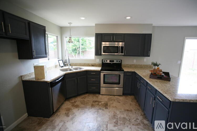 A kitchen with black cabinets and a tiled floor.