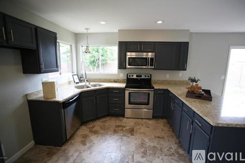 A kitchen with black cabinets and a tiled floor.