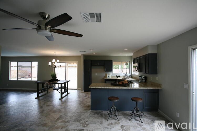 A kitchen with a bar and stools in front of it.