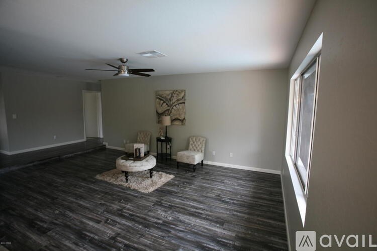 A room with a ceiling fan and two chairs.