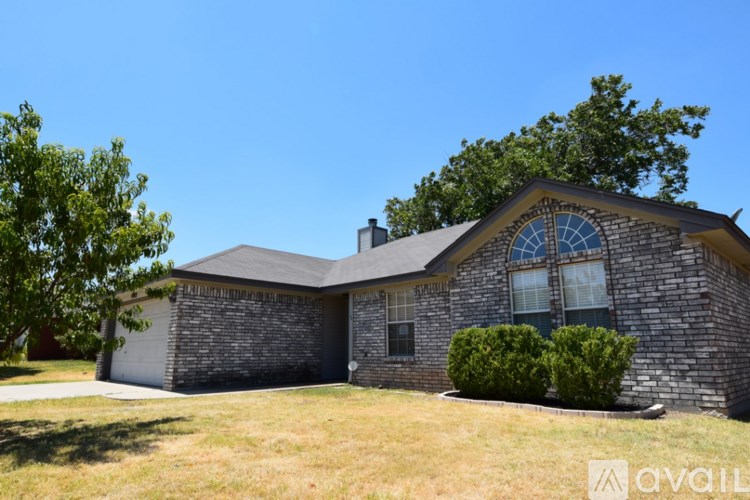 A house with a stone exterior and a large window is for sale.
