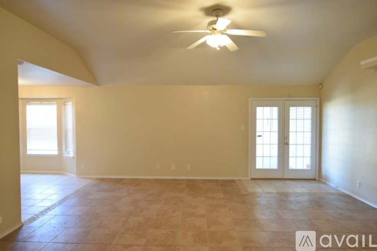 A room with a ceiling fan and tiled floor.