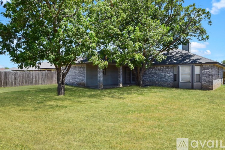 A kitchen with white appliances and wooden cabinets.