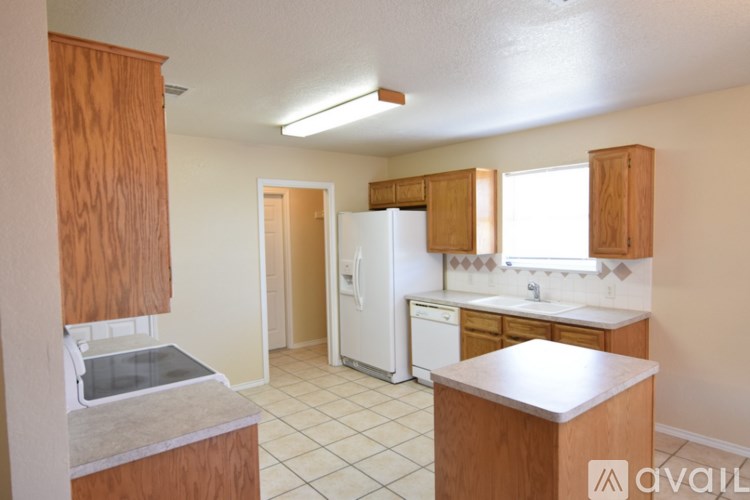 A kitchen with wooden cabinets and a white fridge.