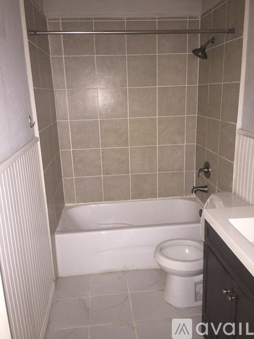 A bathroom with a white toilet and a white bathtub.