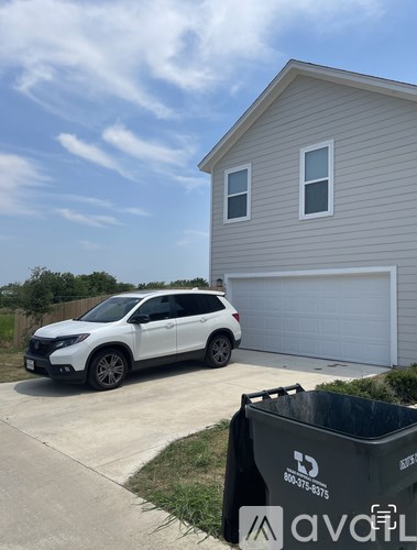 A white SUV is parked in front of a garage.