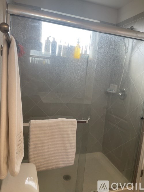 A white towel hangs on a towel rack in a bathroom.