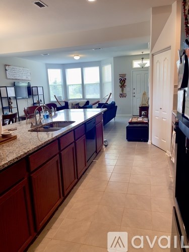 A kitchen with dark wood cabinets and a granite countertop.