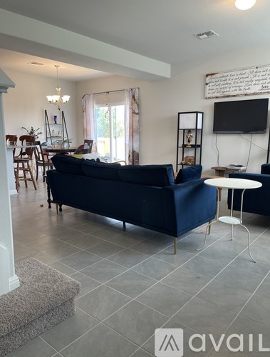 A living room with a blue couch and a white table.