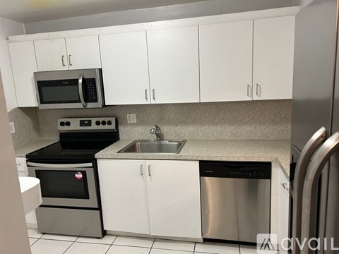 A kitchen with white cabinets and stainless steel appliances.