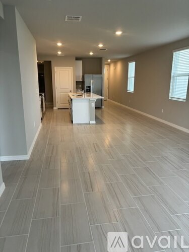 A spacious room with a kitchen island in the middle.