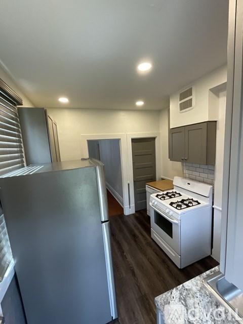 A kitchen with a stove and a refrigerator.