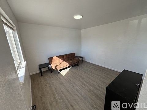 A living room with a brown couch and a black cabinet.