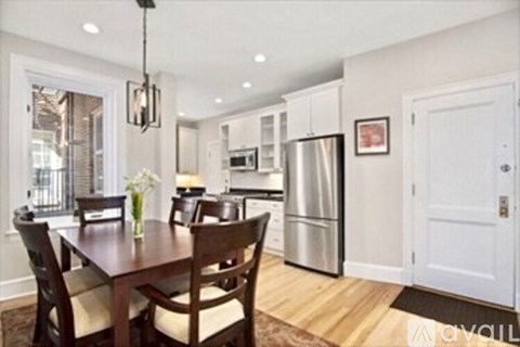 A kitchen with a table and chairs in the foreground.