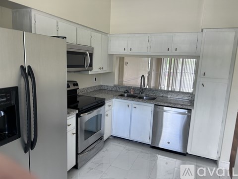A kitchen with white cabinets and stainless steel appliances.
