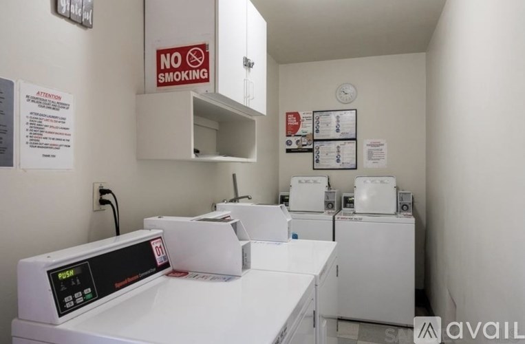 A white room with a no smoking sign and a clock on the wall.