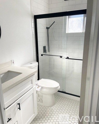 A white toilet in a bathroom with a walk-in shower.