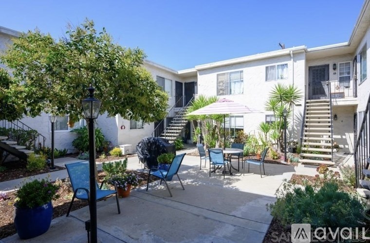 A sunny day at a residential outdoor patio with a table and chairs.