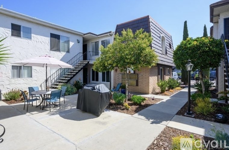A sunny day at a residential area with houses and a patio.