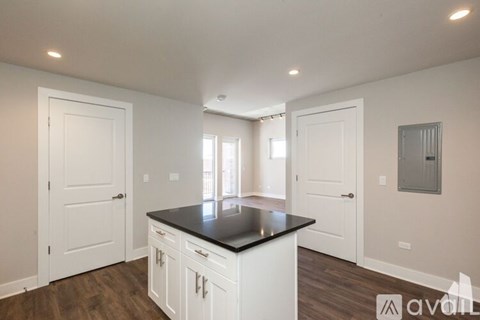 A kitchen with white cabinets and a black countertop.