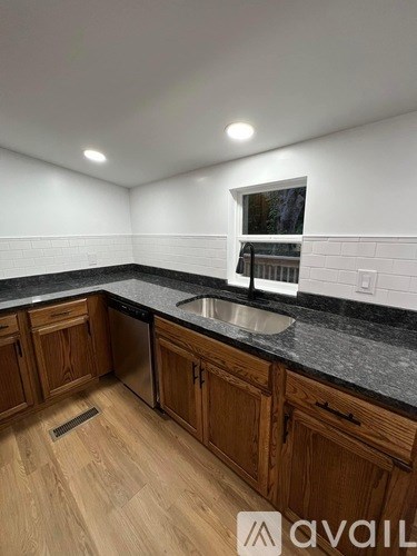 A kitchen with wooden cabinets and a black countertop.