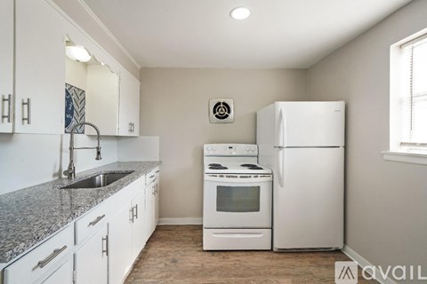 A kitchen with white appliances and cabinets.