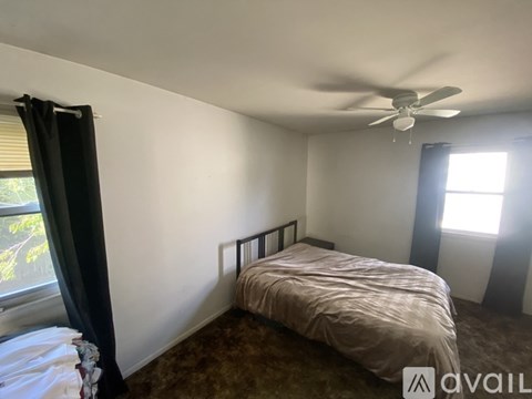 A bedroom with a bed, desk, and chair.