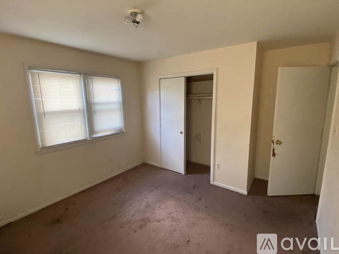 A bedroom with a bed, desk, and chair.