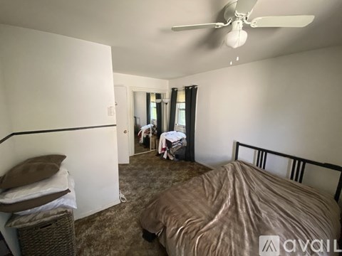A bedroom with a bed, desk, and chair.