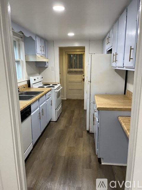 A kitchen with white cabinets and a wooden countertop.