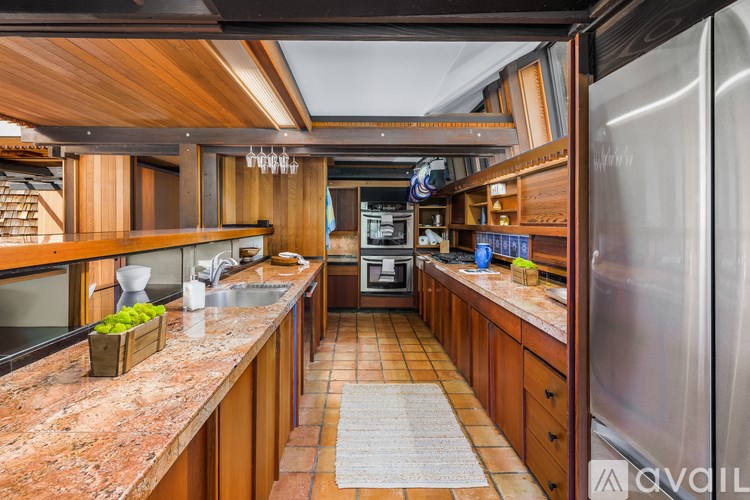 A kitchen with wooden cabinets and a granite countertop.
