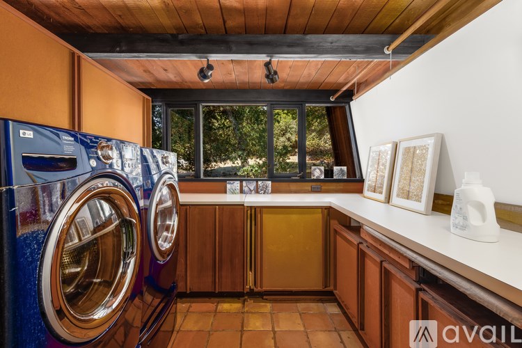 A laundry room with a washing machine and a window.