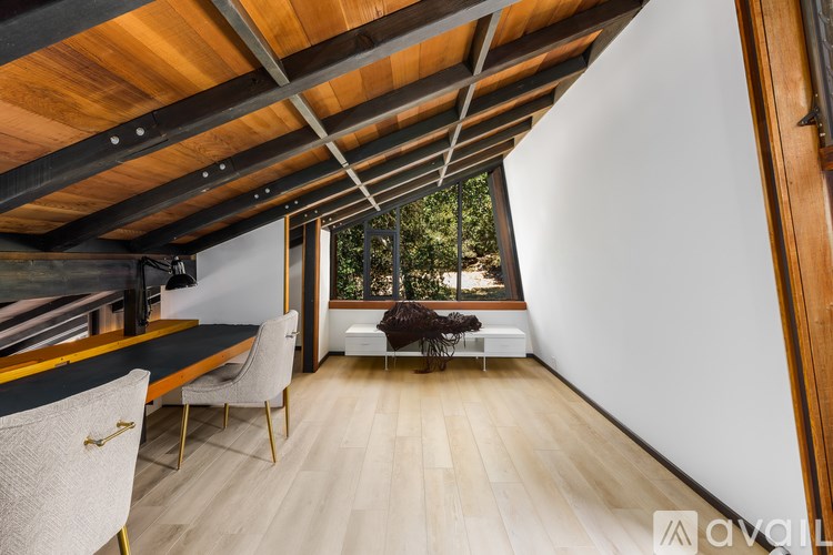 A room with a wooden ceiling and a white chair.