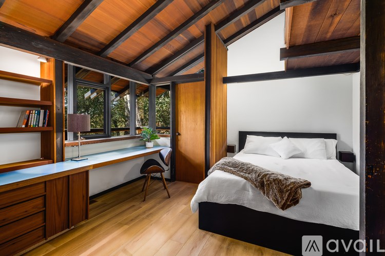 A bedroom with a bed, desk, and chair.