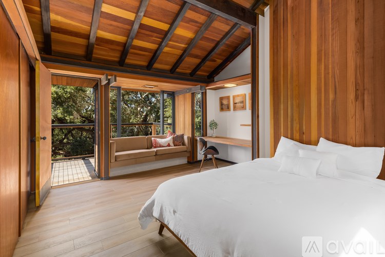 A bedroom with a bed, a couch, and a chair in it.