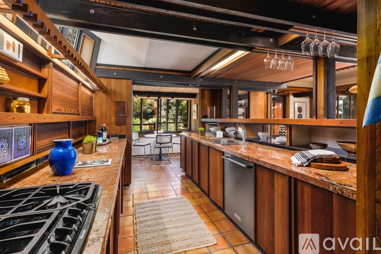 A kitchen with wooden cabinets and a blue vase on the counter.