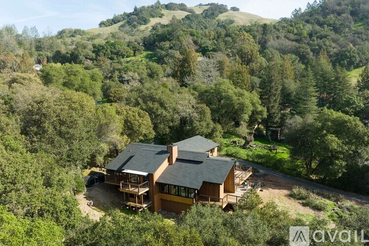 A house surrounded by trees in a hilly area.
