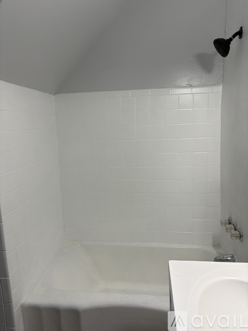 A white bathroom with a tub and a toilet.