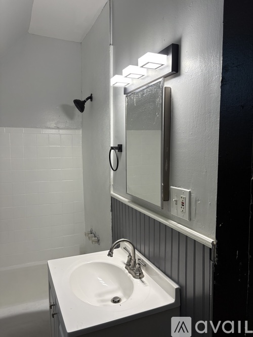 A white sink in a bathroom with a mirror above it.