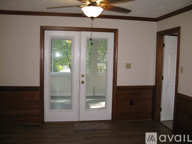 A bathroom with a toilet, sink, and window.