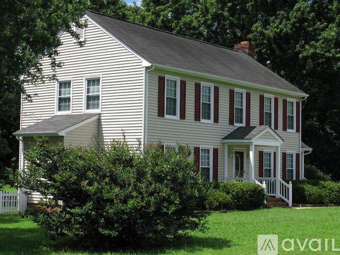 A house with a white picket fence in front.