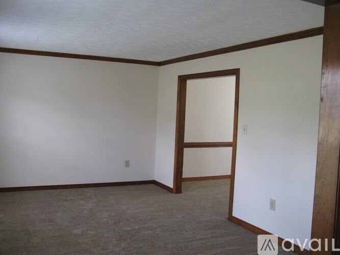 A room with a carpeted floor and a door.