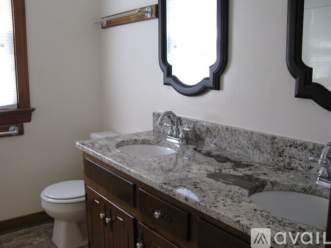 A bathroom with a granite countertop and a toilet.