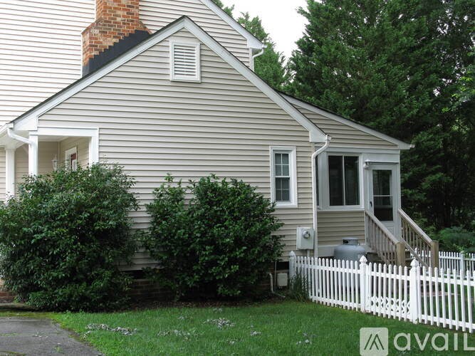 A house with a white picket fence in front.