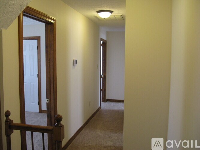 A hallway with a door on the left and a light on the ceiling.