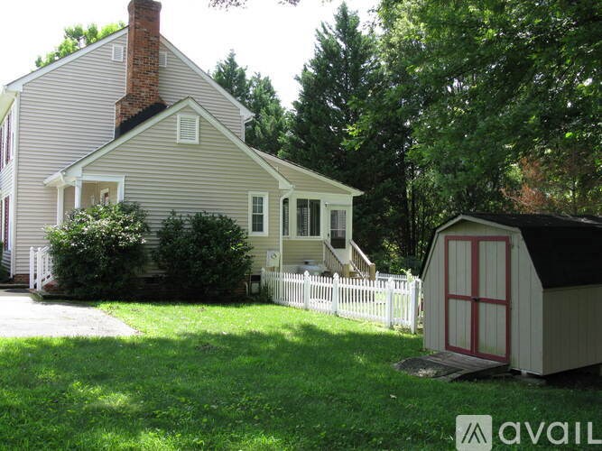A house with a red door and a white fence.