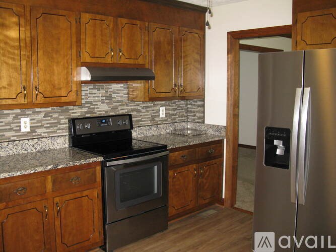 A kitchen with wooden cabinets and a black stove top oven.