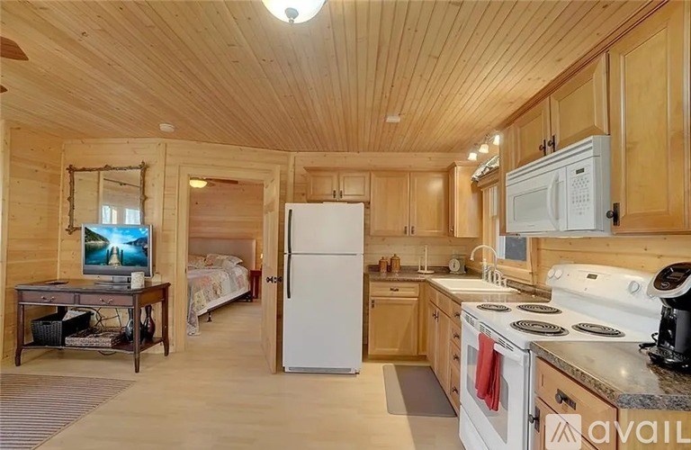 A kitchen with wooden cabinets and a white fridge.