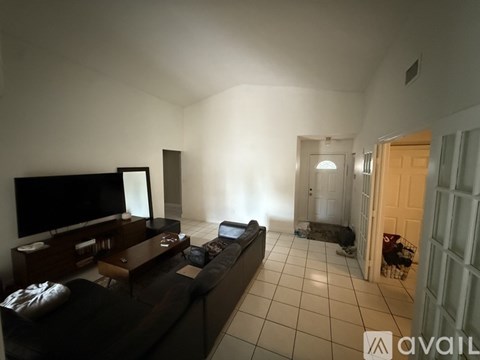 A living room with a black couch and a television.